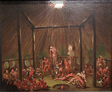 A painting shows several young Indian men suspended by wooden splints, which are stuck through different parts of their bodies. Others participate in the ritual or look on from below.
