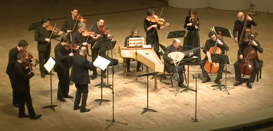 A small string Baroque Orchestra performs.
