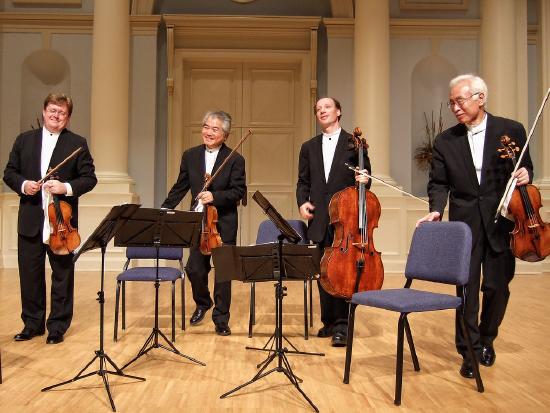 Picture of four members of a string quartet including two violinists, a violist, and cellist.