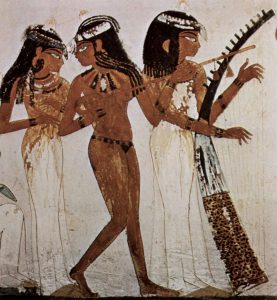Three people in long dresses playing instruments with long dark hair.