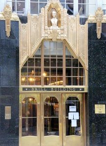 Color photographic image of the Bill Building. The building has three gold doors, glass windows, and decorative elements.