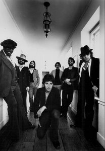 Black and white photo of Bruce Springsteen (center) and the E Street Band (behind him).