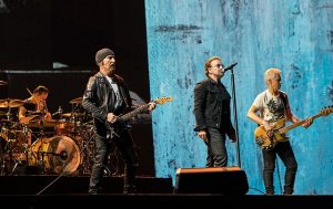 Color photo of U2 performing live.