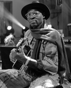 Color image of Ali Farka Toure singing and playing guitar.